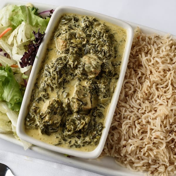 Creamy Indian spinach and chicken curry with rice and a side salad.